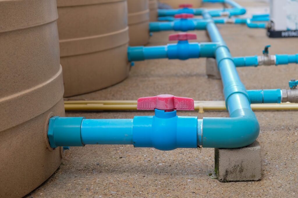 Blue water pipe installation from pump to tank.