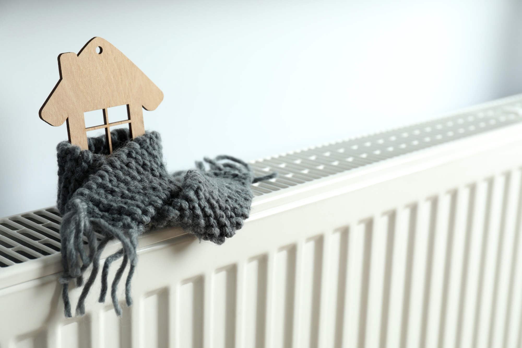 Concept of heating season with wooden house on heating radiator
