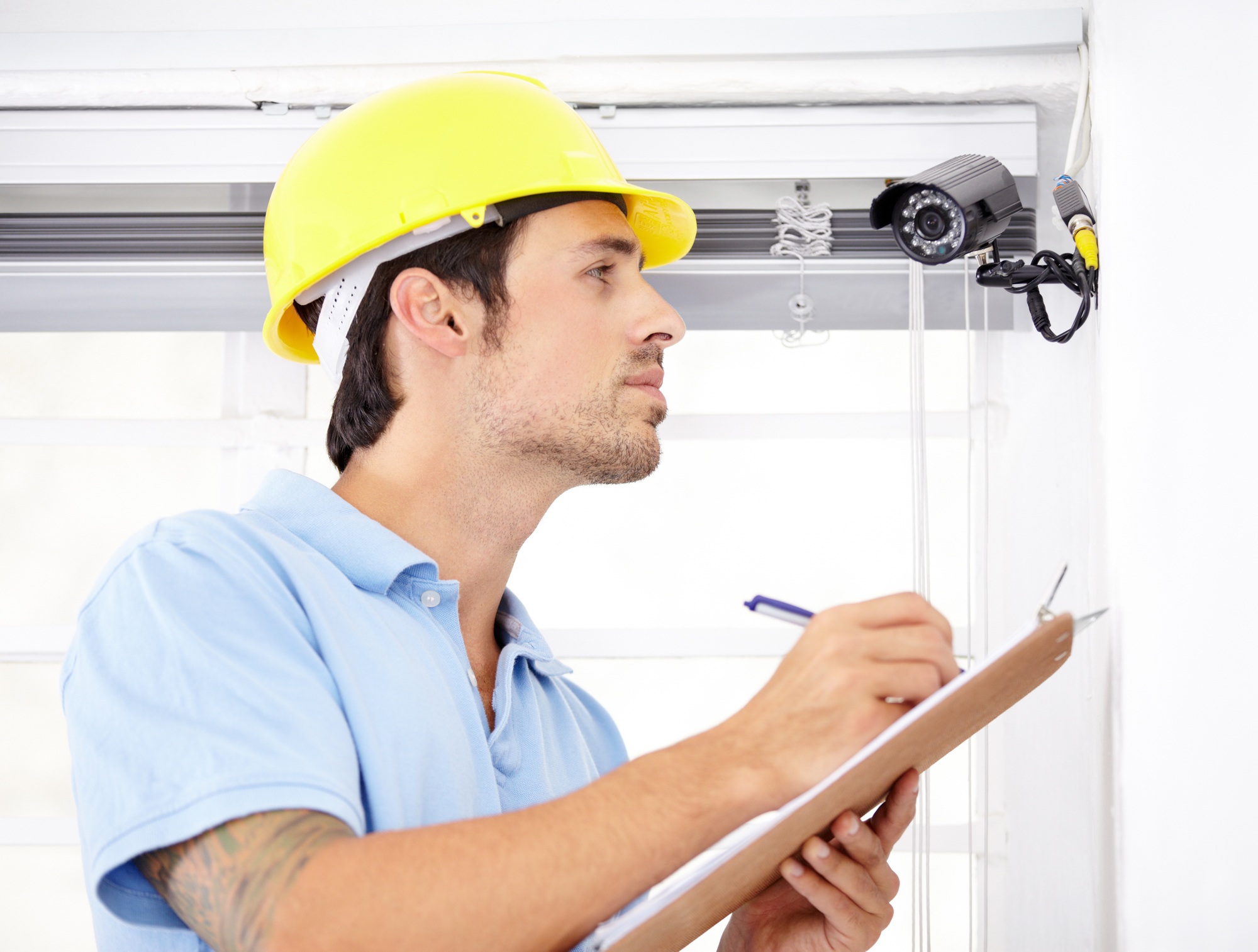 Contracted to secure your home. Shot of a handsome young man installing a security camera.